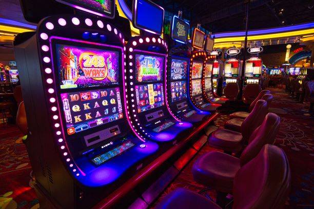 A row of slot machines with bright lights.